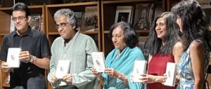 Five people standing in a line holding a book called 'exObjects'. The first man is an author, the second man is the book publisher, the first woman is director of Bangalore International Centre, and the second and third woman are both authors and co-editors of the book.