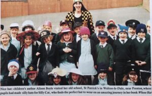 Womanin centre of rows of children wearing hats in a school playground