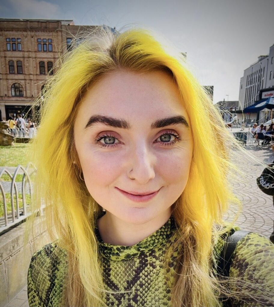 Image of a woman standing outside, with yellow hair